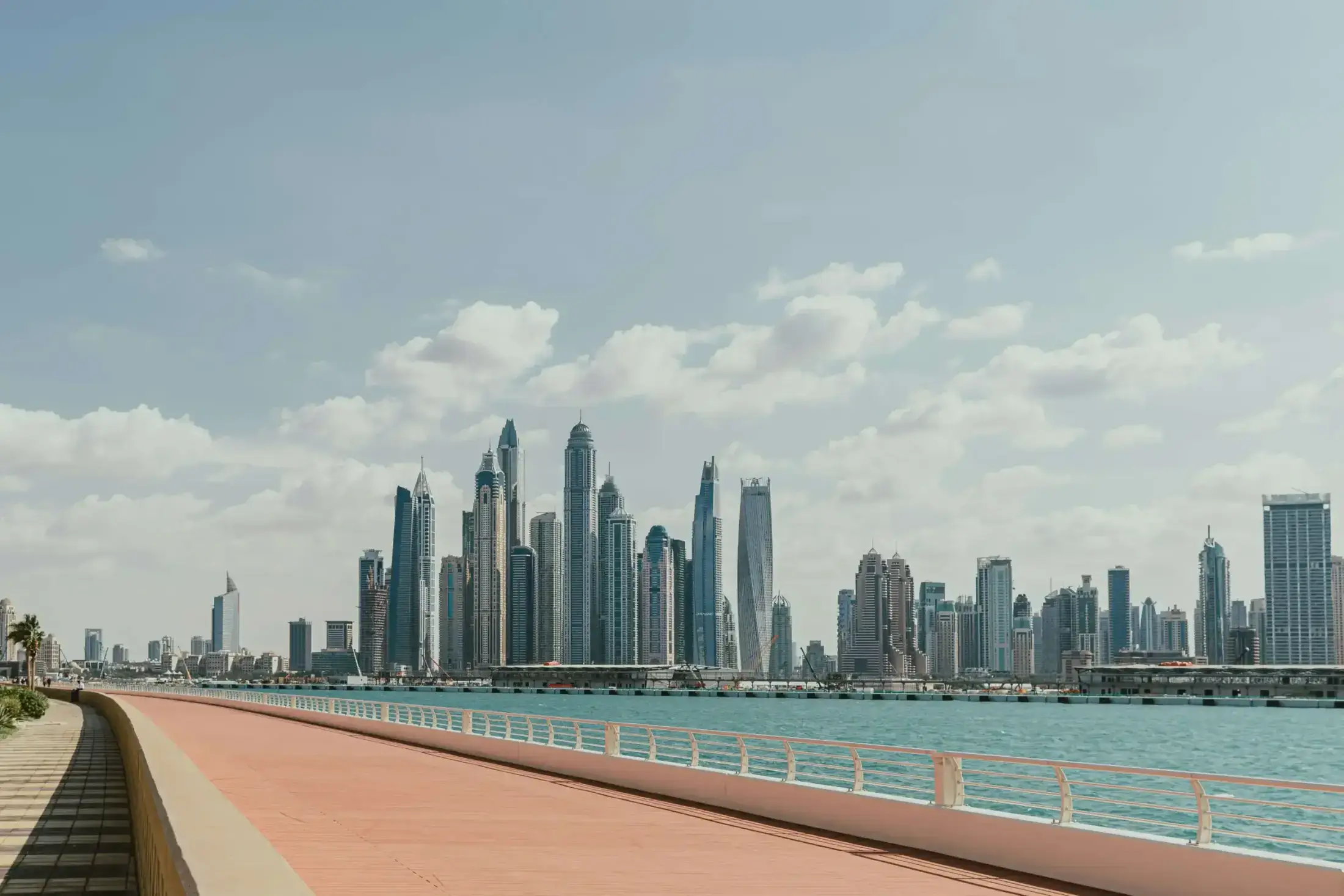 Skyline of Dubai Marina skyscrapers across turquoise water.