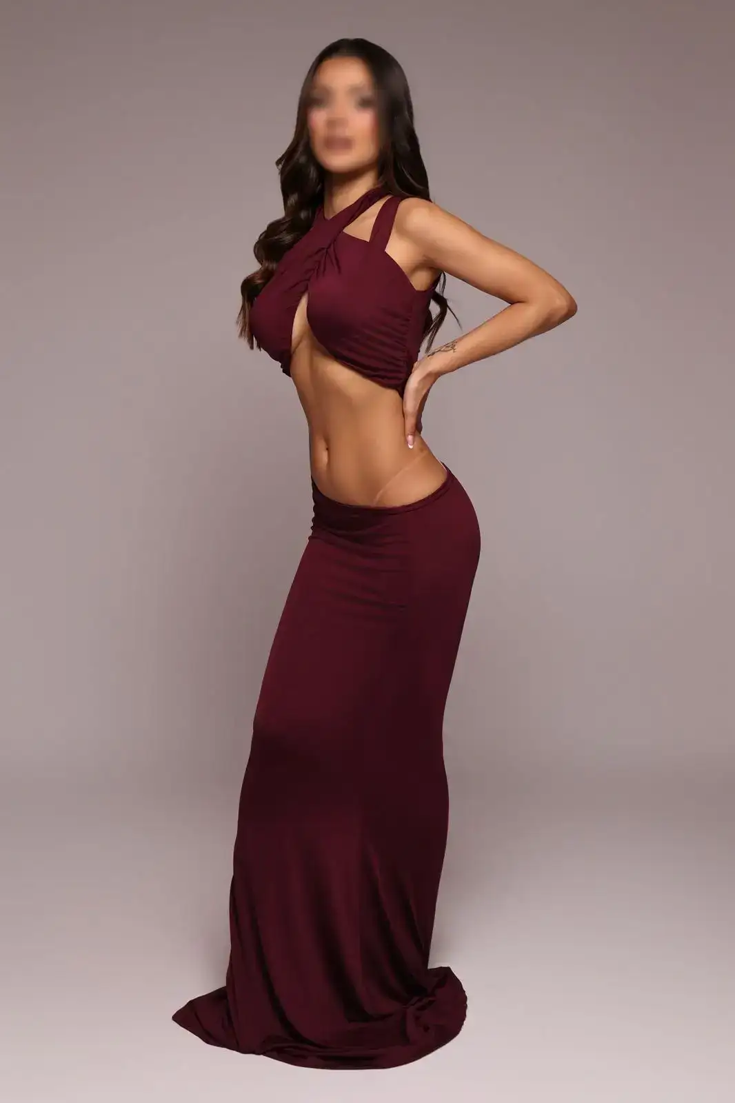 Woman posing in a burgundy crossover top and maxi skirt.