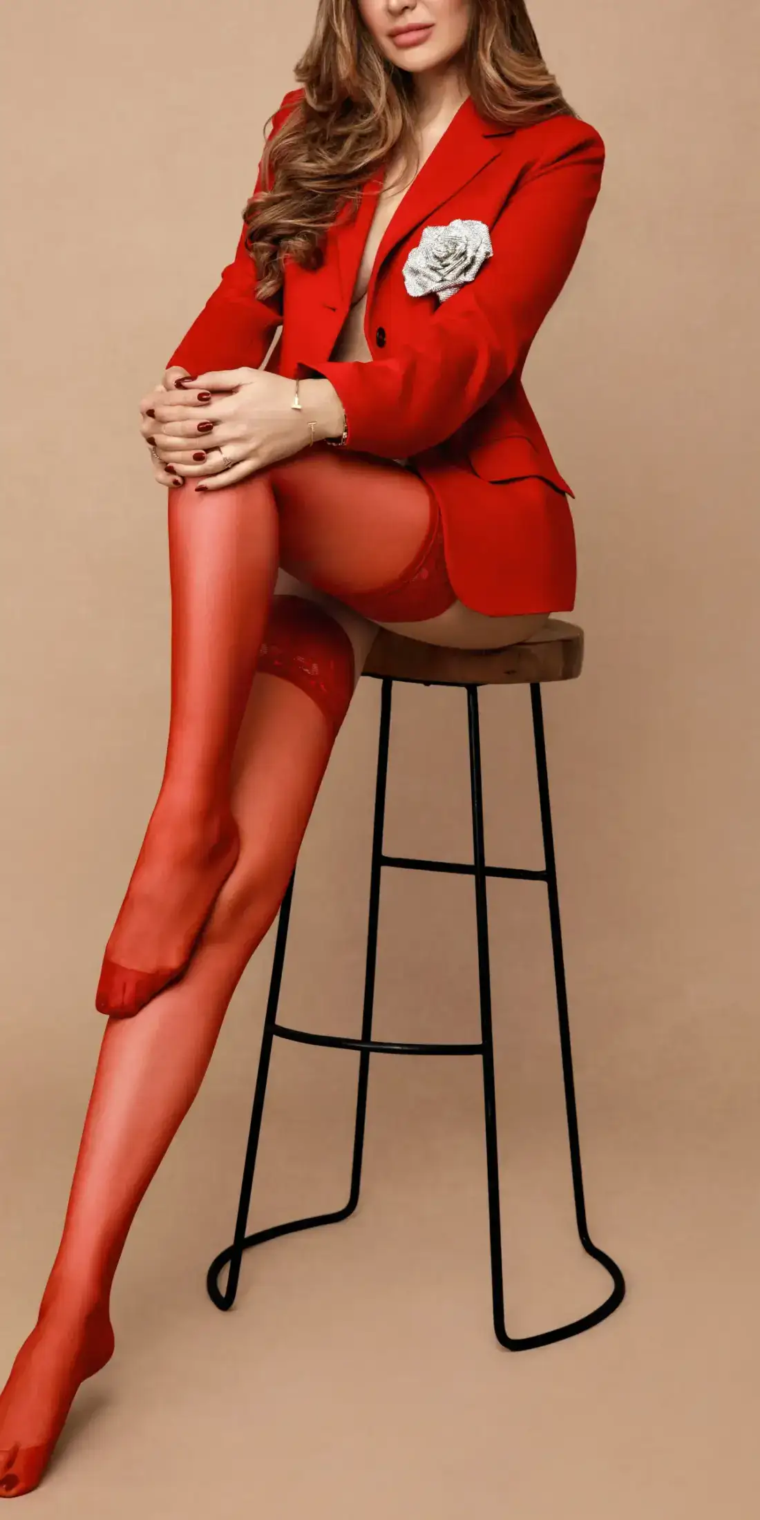 Woman posing in a red blazer and red stockings.